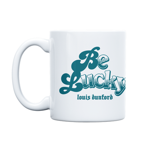 Front view of a white ceramic mug displaying ‘Be Lucky’ in bold blue lettering on each side, accompanied by ‘Louis Dunford’ in a smaller blue typewriter-style font underneath.